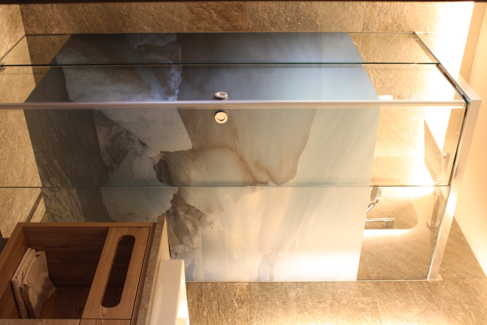 Divisorio in vetro in bagno con motivo montano stampato sopra il lavabo