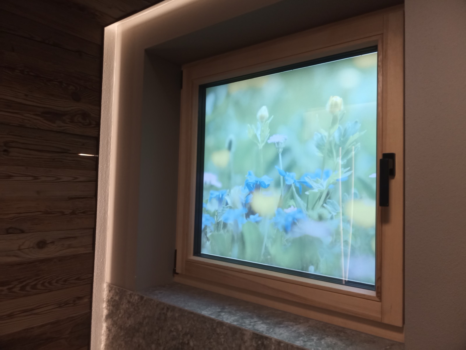 Finestra in legno con pellicola stampata a prato fiorito come privacy