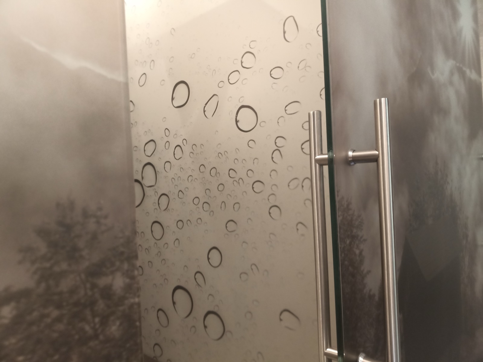 Porta in vetro con motivo a gocce e maniglia in acciaio in bagno